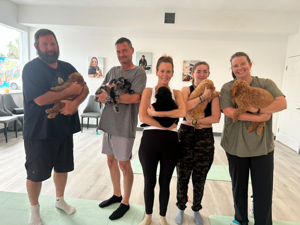 Guests holding puppies after a Pawsitively Pilates class