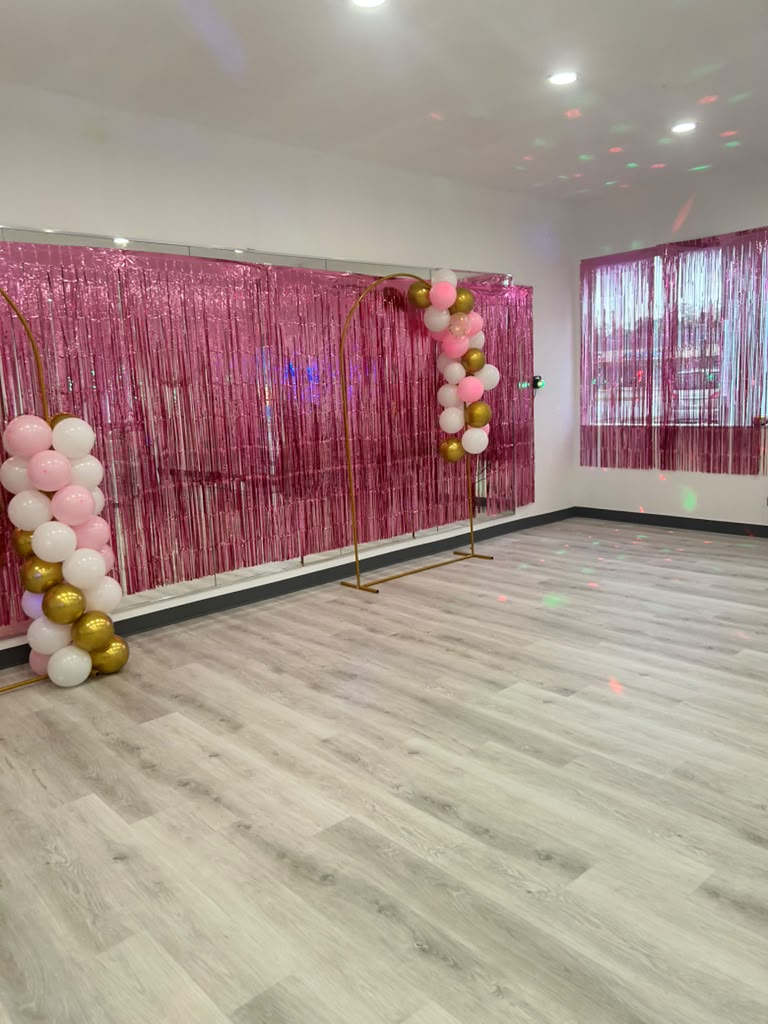 Studio decorated for a party with balloon arch and pink backdrop