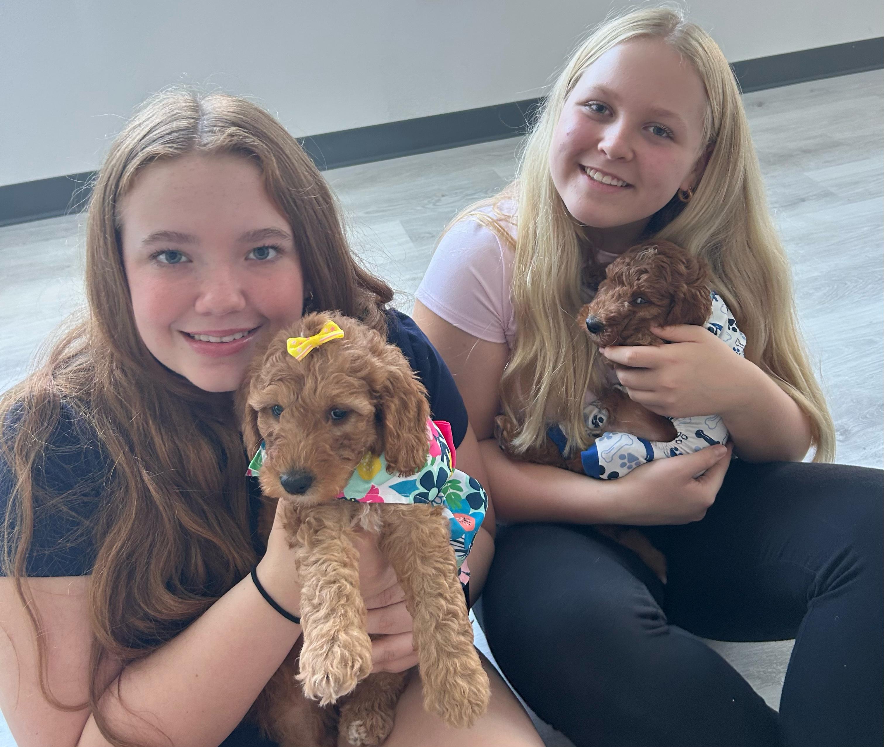 Two girls holding puppies during a private group session